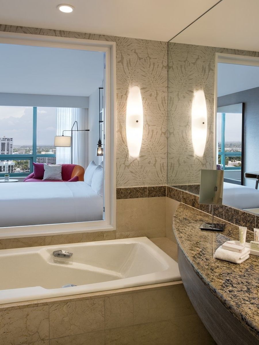 Intracoastal view full bathroom with a tub near the sink, 2 mirrors & robes with towels at The Diplomat Resort