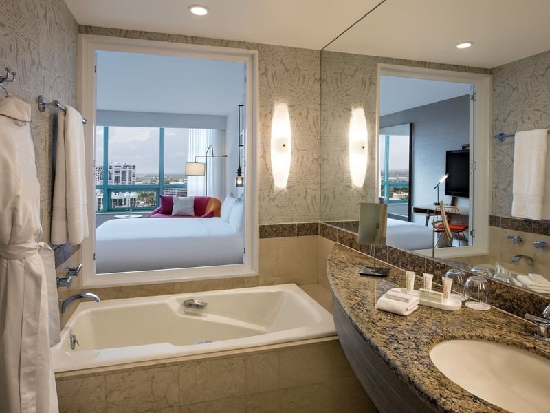 Intracoastal view full bathroom with a tub near the sink, 2 mirrors & robes with towels at The Diplomat Resort