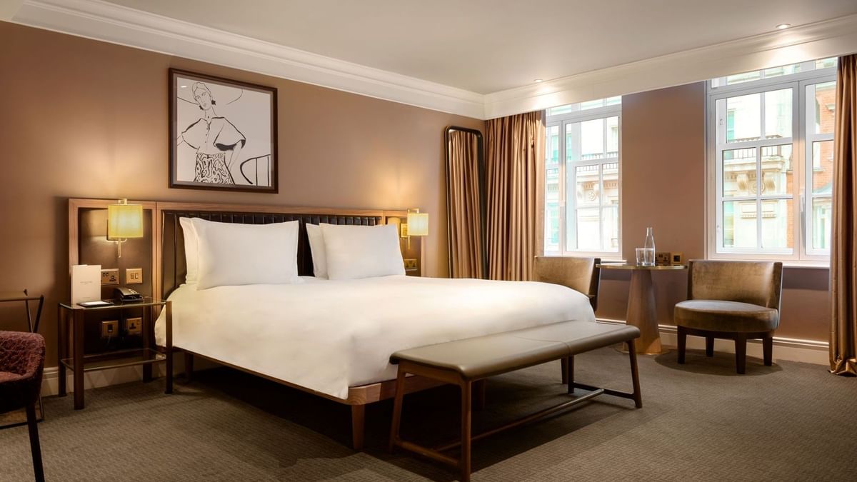 Elegant Collection Superior Room with a large bed and cozy seating area at The May Fair Hotel, London.