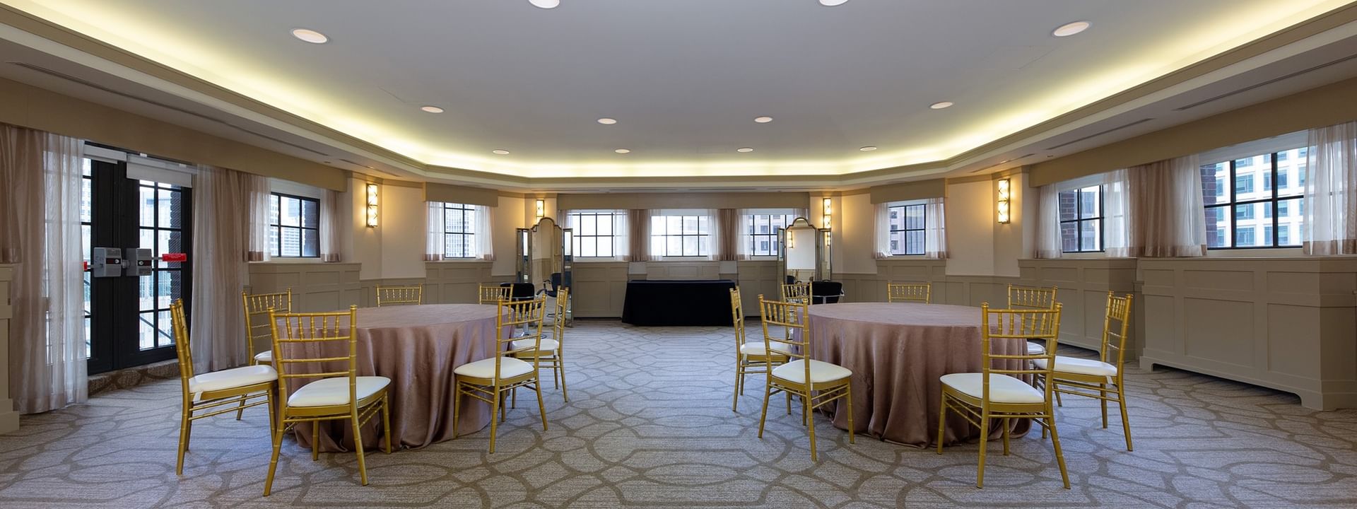 Two banquet tables by glass doors under recessed lighting in 	
Michigan Room at Warwick Allerton Chicago
