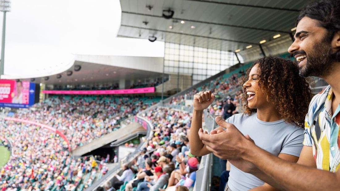 Excited fans cheering in a packed cricket stadium during the Australia v New Zealand Test Series 2027