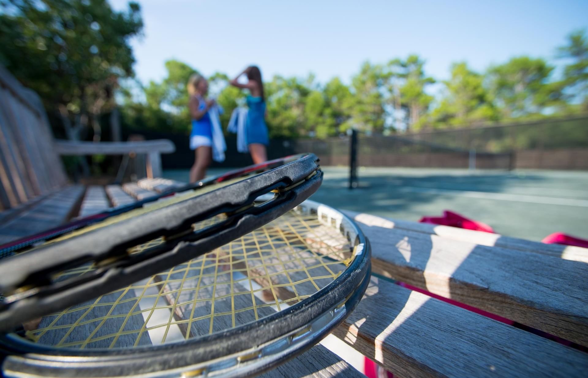 Close-up of tennis rackets on the bench by the court at Watersound Inn