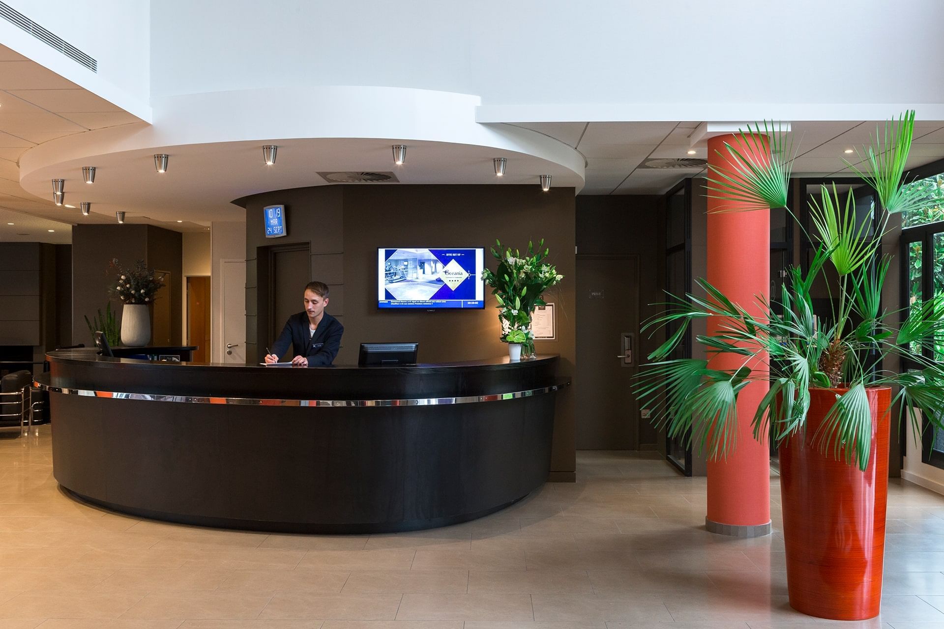 Receptionist by the front desk at Oceania Nantes Aéroport