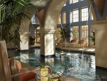 Relaxing indoor pool at Hilton Santa Fe Buffalo Thunder with elegant arches and cozy lounge seating