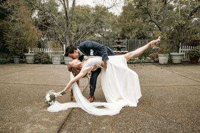 Groom dipping and kissing his bride during their wedding at Lake Natoma Inn