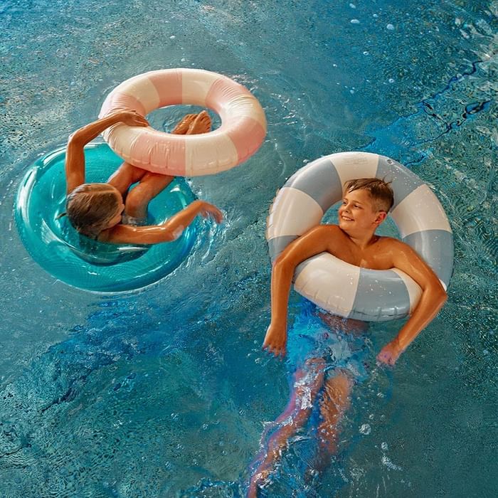Two children floating in pool rings at Falkensteiner Resort Lake Garda