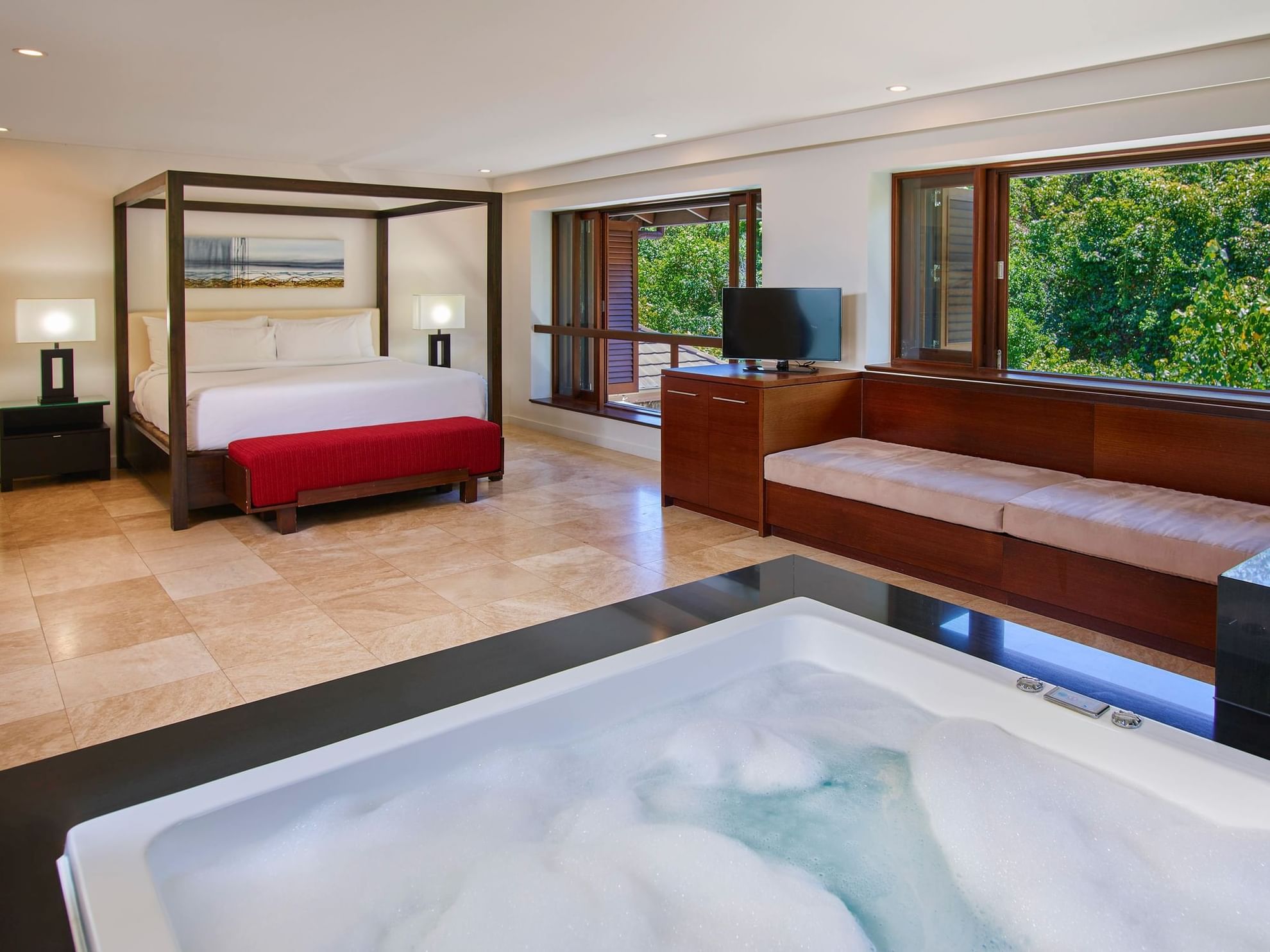 Three-Bedroom Villas with large bed, TV, seating area & filled bathtub at Pullman Port Douglas Sea Temple Resort & Spa