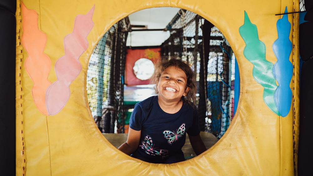 Smiling girl inside the Funtastik Kids Club play area at Warwick Le Lagon Efate.