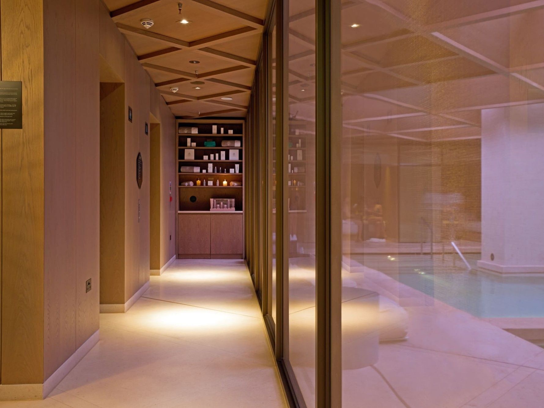 Interior of The Retreat at The Londoner, featuring wellness products and sheer glass windows overlooking the pool area.