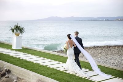 Wedding couple holding hands by the sea at Villa Premiere Boutique Hotel & Romantic Getaway
