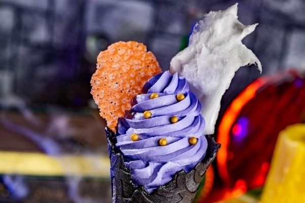 A black ice cream cone with purple soft serve and a cotton candy garnish from Mickeys Not So Scary Halloween Party at Magic Kingdom.