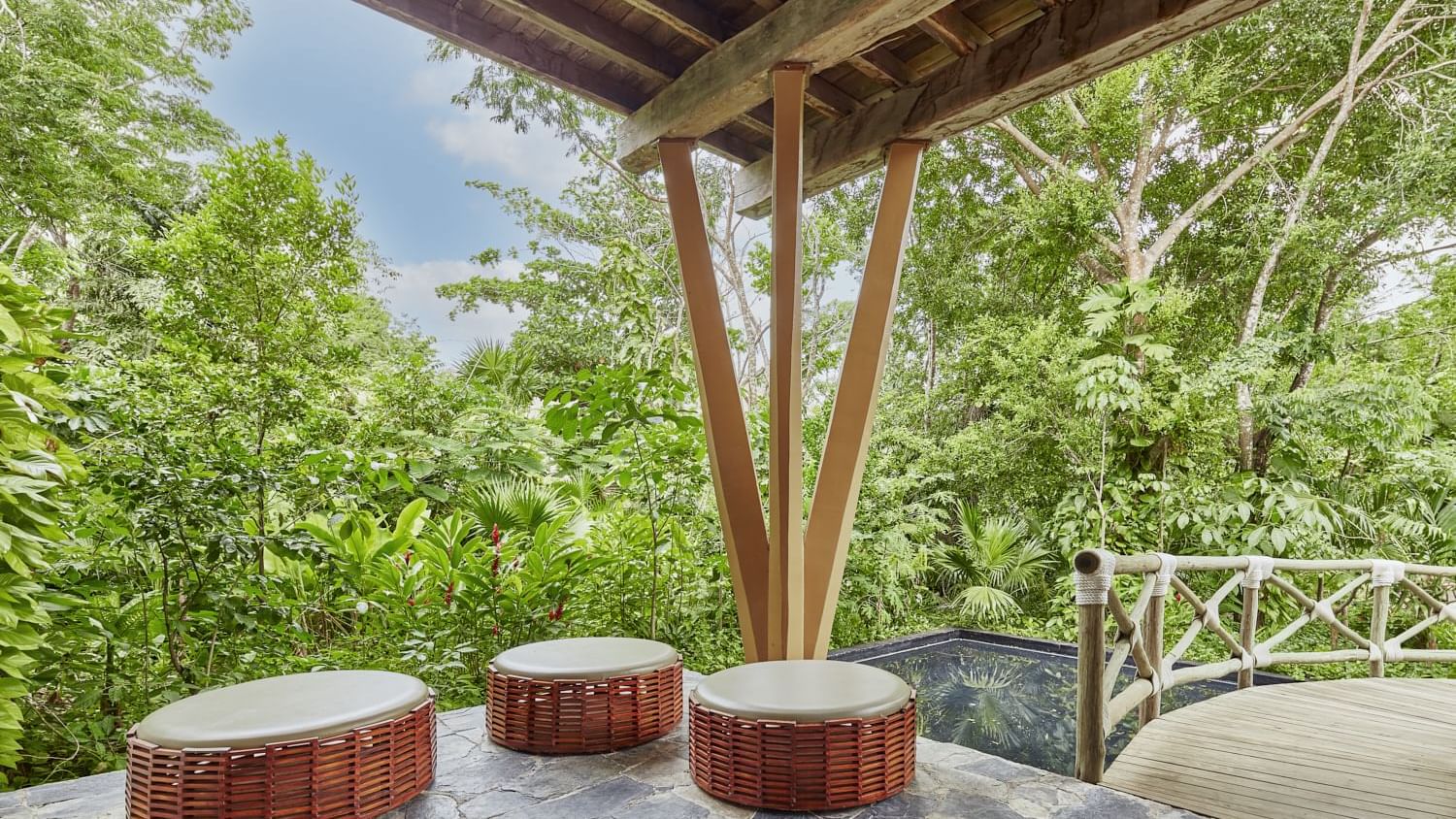 Outdoor lounge area with Rattan Round Loungers by lush greenery at The Explorean Cozumel