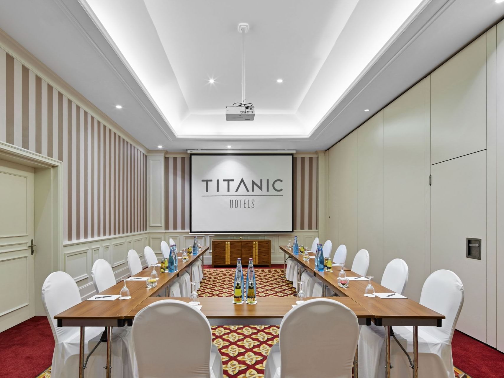 Tische vor dem Projektor im Private Room I im Titanic Gendarmenmarkt Berlin angeordnet