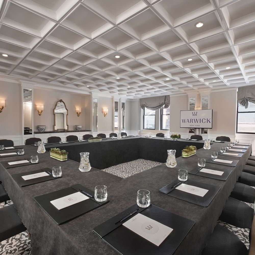 Boardroom table set-up facing TV near window in Westminster meeting room at Warwick New York