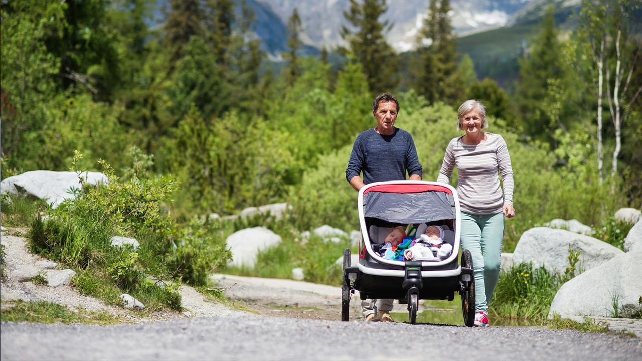 Two grandparents push a double stroller with sleeping twins in Canmore.