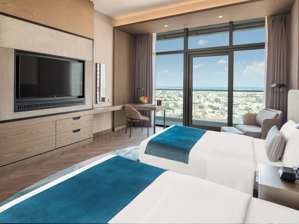 Twin beds and a TV by the balcony view in Scene Room Duet at Paramount Hotel Midtown