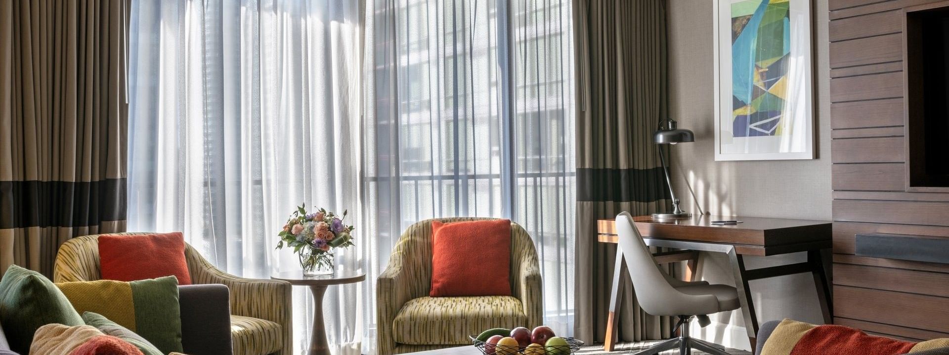 Queen Anne Suite features two armchairs by a coffee table near a desk and window at Warwick Seattle