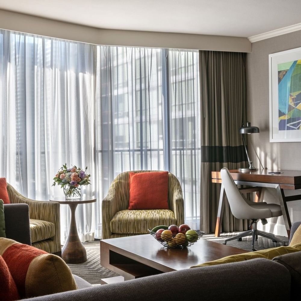 Queen Anne Suite features two armchairs by a coffee table near a desk and window at Warwick Seattle