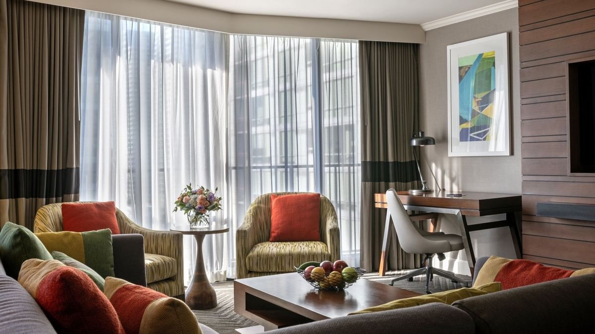 Queen Anne Suite features two armchairs by a coffee table near a desk and window at Warwick Seattle