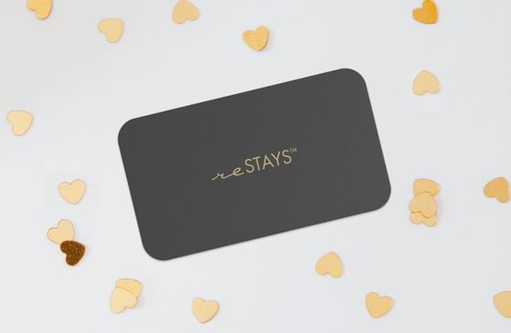 A dark gray business card with gold lettering reSTAYS™ used by ReStays Ottawa