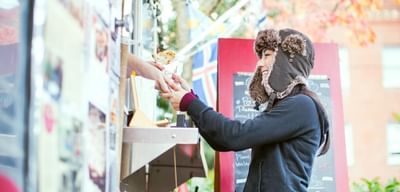 A woman purchasing food from a food truck near Paramount Hotel
