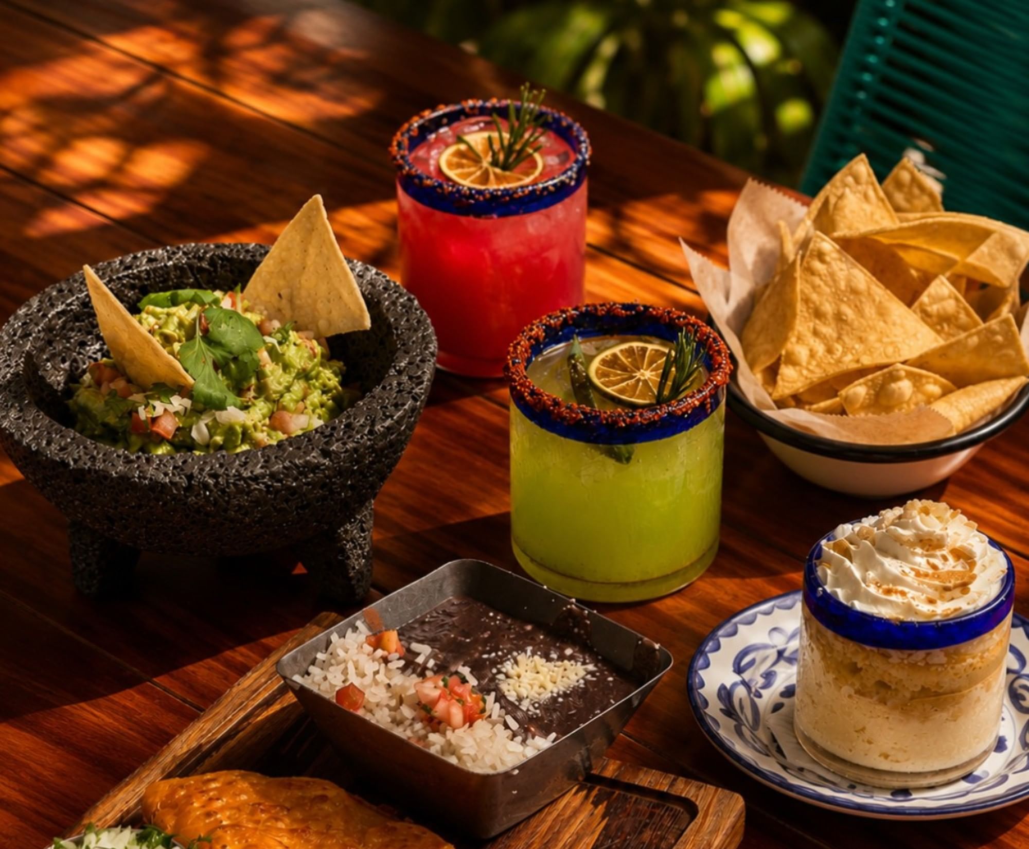 A spread of Mexican food and drinks on a wooden table