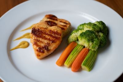 Grilled heart-shaped salmon fillets served alongside steamed broccoli & carrots in Seasons Restaurant at Warwick Hotel Jeddah