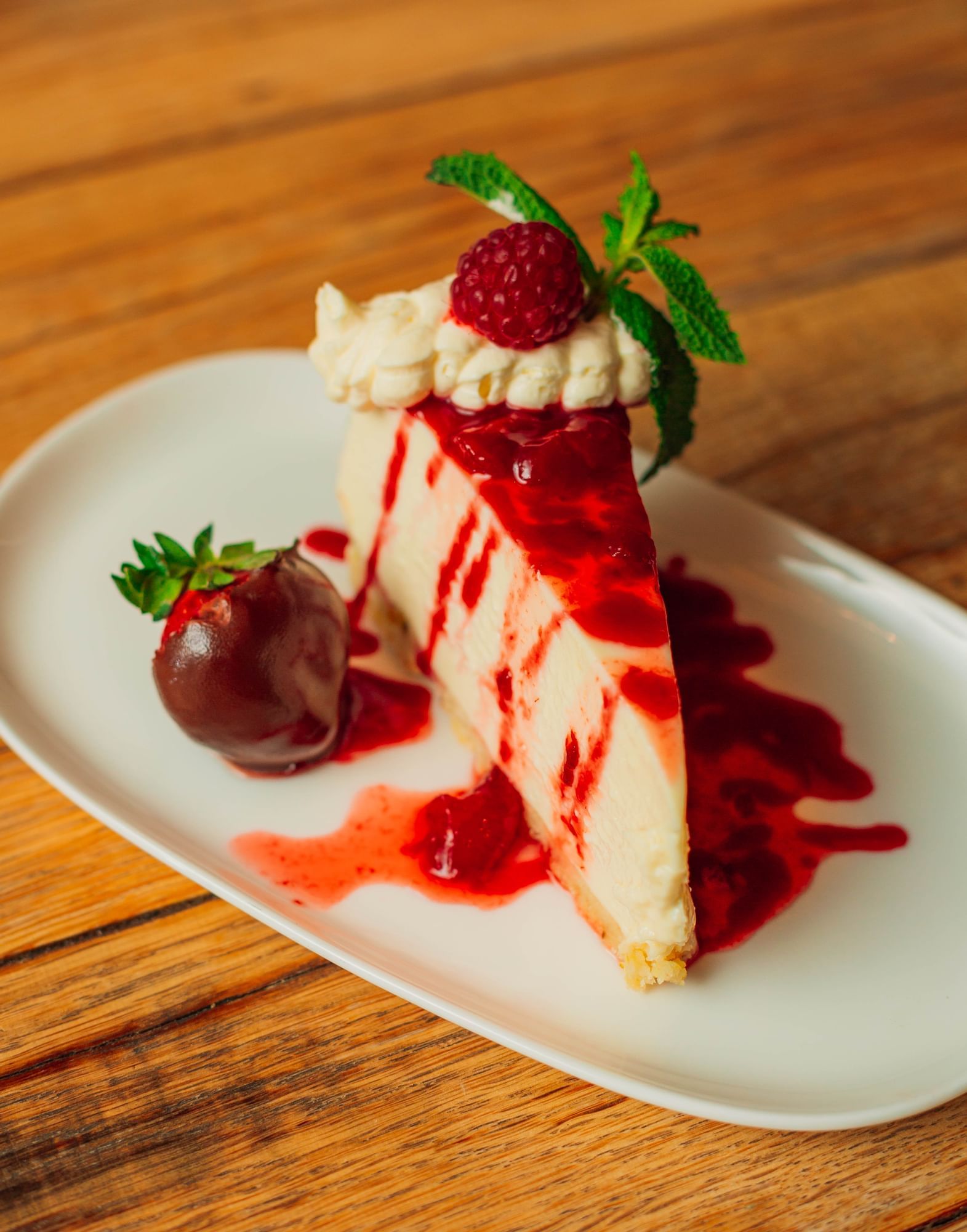 Lorem ipsum Cheesecake slice topped with berries and red sauce