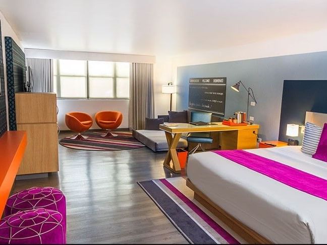 TRYP by Wyndham Isla Verde hotel room with bed, desk and sofa