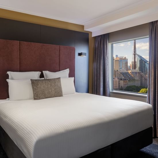 Junior Suite with cozy bed and a city view at Pullman Sydney Hyde Park