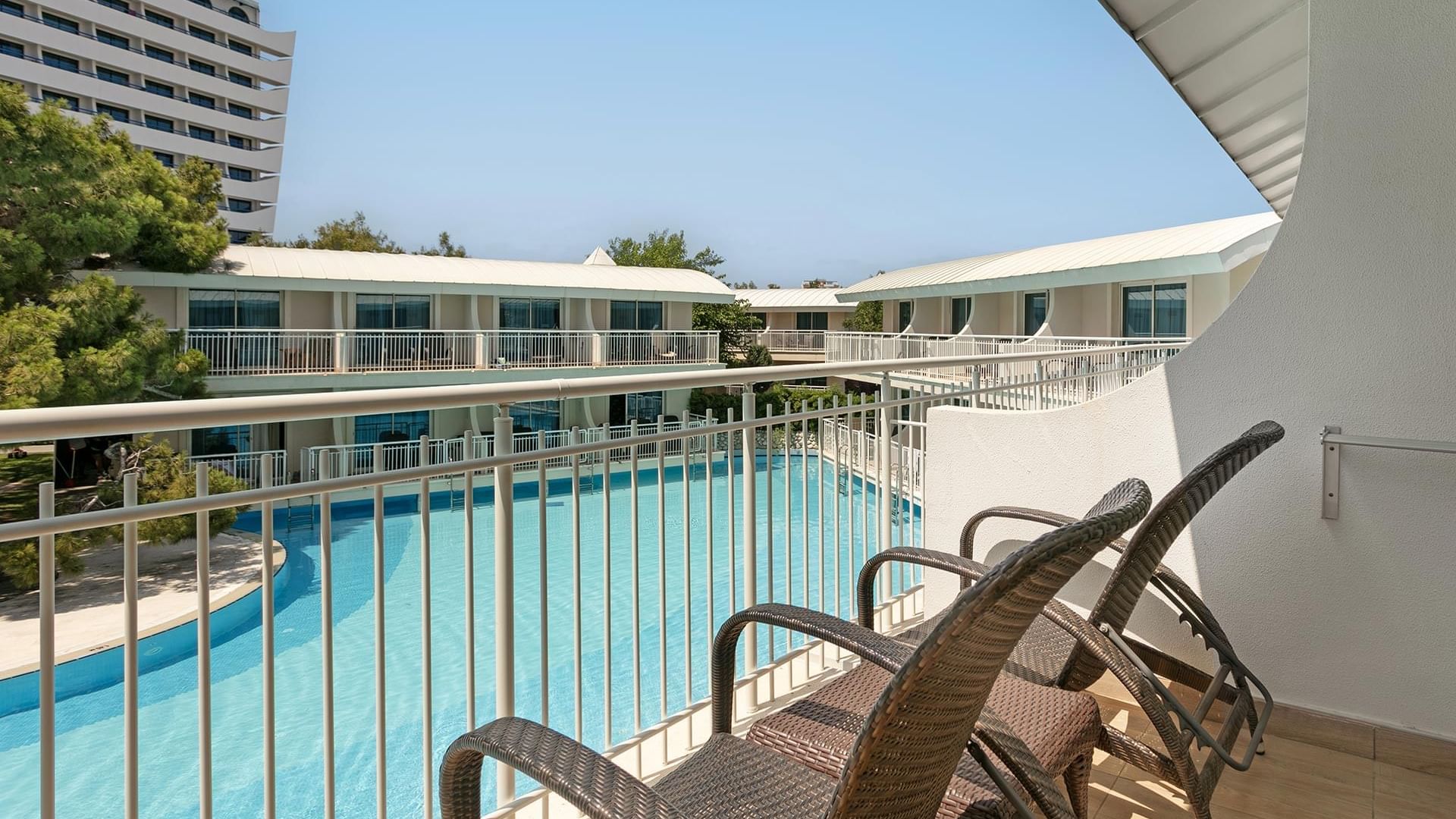 Titanic Deluxe Lara – Annex Standard Pool’da havuz manzaralı balkonda şezlonglar.