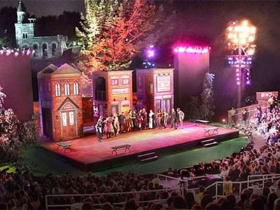 Outdoor stage performance unfolding before a packed nighttime audience at Colonial Theatre near Breezeway Boutique Hotel