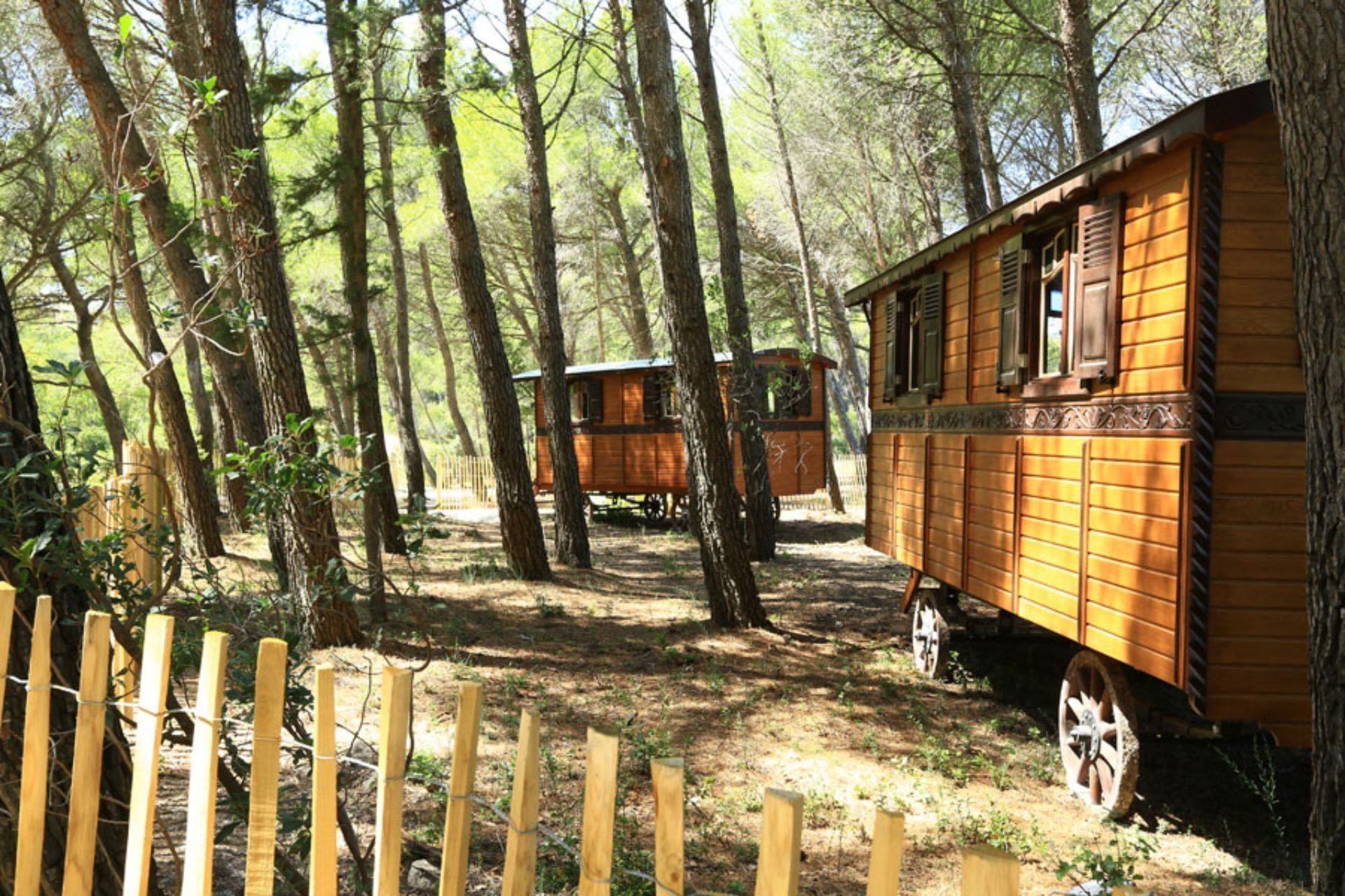 Trailer Cabins in a Forest by a fence at Domaine De Manville