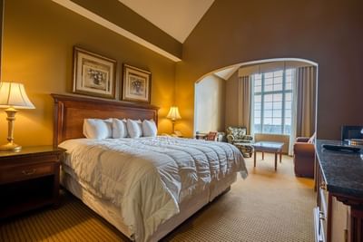 Seating area and wooden cabinet by the bed in Standard King at The Wildwood Hotel