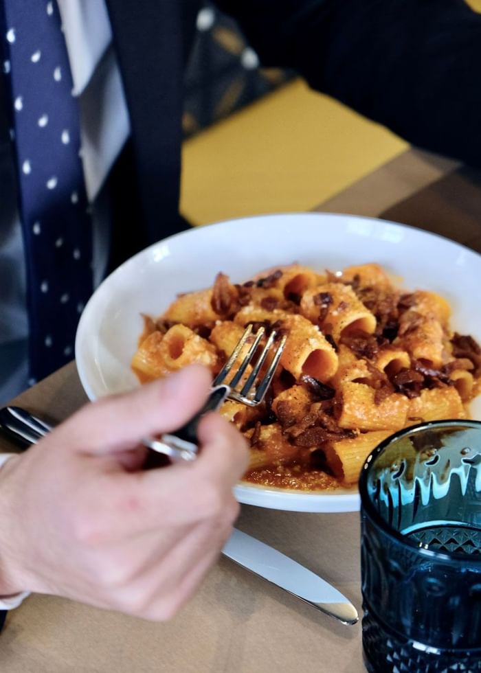 Close-up of a man in suit eating pasta with a fork at Da Mariolino Restaurant