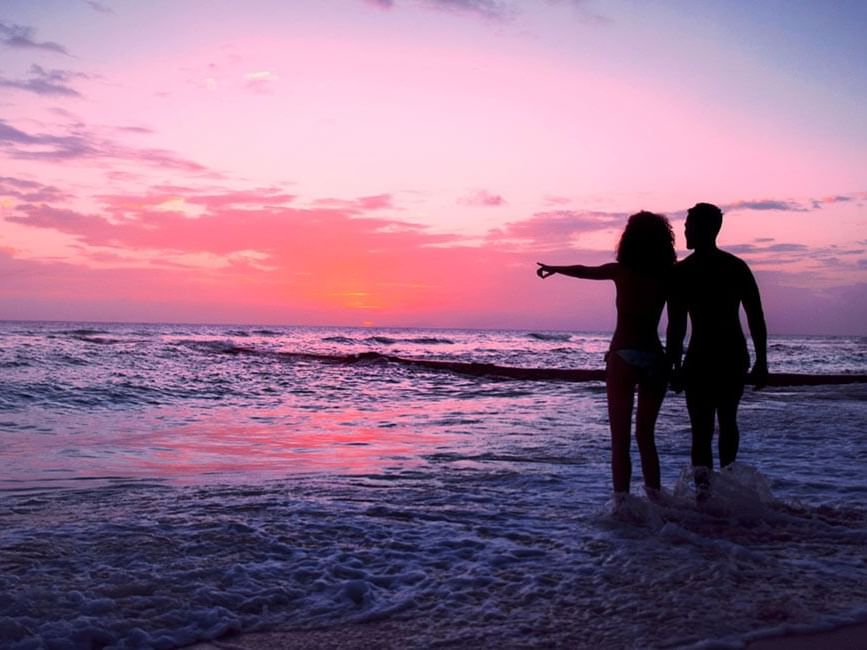 Couple watching  sunset from the shore near Sugar Bay Barbados