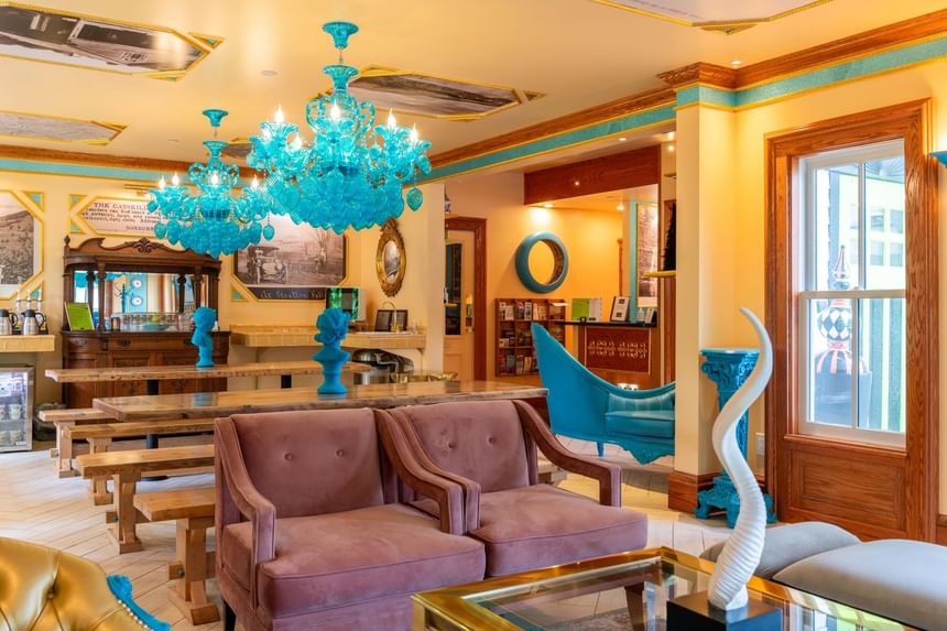 Brightly colored lounge with turquoise chandelier and unique furniture at The Roxbury