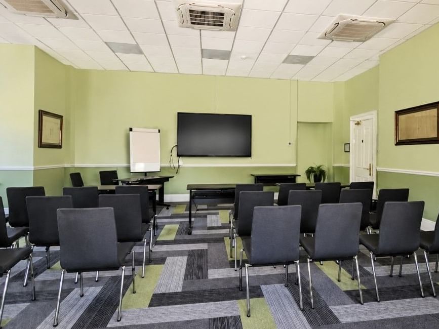 Sandys event room with theatre-style seating, presentation screen and natural light at Easthampstead Park Hotel