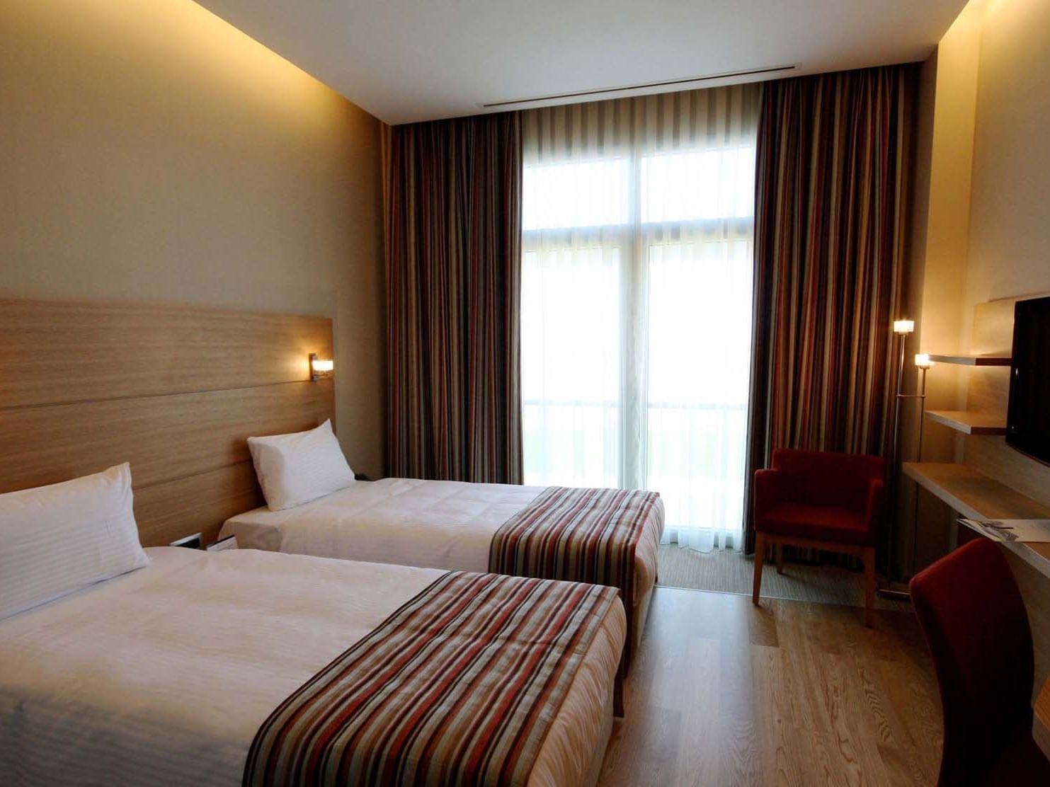 Twin beds, chairs and a work area with TV in the Superior Room at Titanic Anadolu Gebze