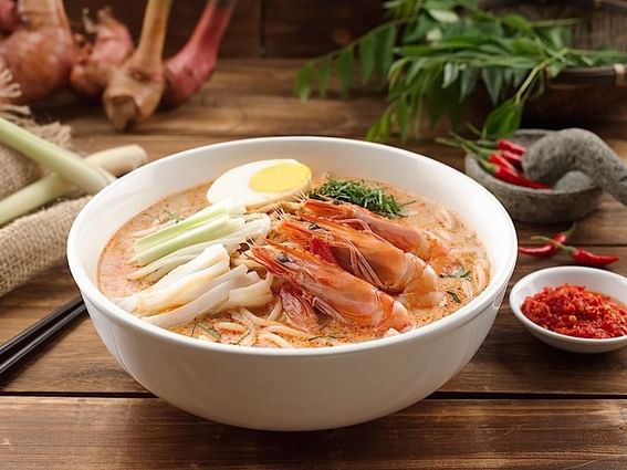 Bowl of laksa topped with shrimp & vegetables in White Rose Café at York Hotel Singapore