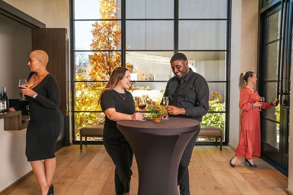 People in attire at an indoor social event with drinks in The Study at University of Chicago