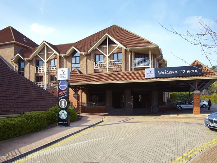 An exterior view of the hotel & car park at Village Hotels