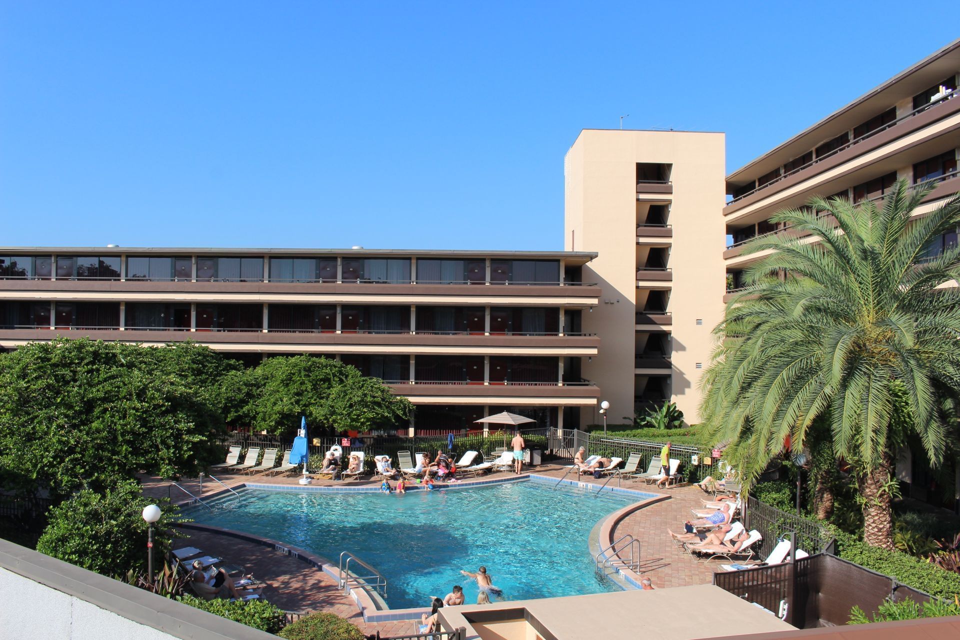 A large pool area with a pool, lounge chairs, and a building in the background.