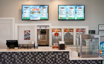The Sweet Shack counter and menu boards featuring soft-serve ice cream and frozen drink machines at Centennial Plaza Resort