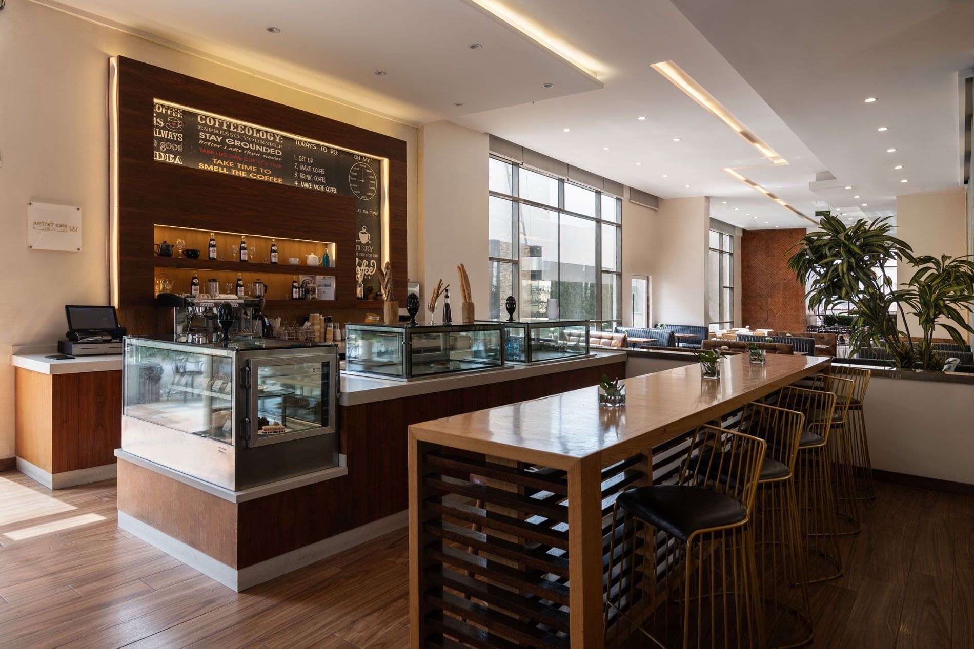 Artist Lobby Lounge with warm wood tones, high seating, and large windows at Warwick Hotel Jeddah