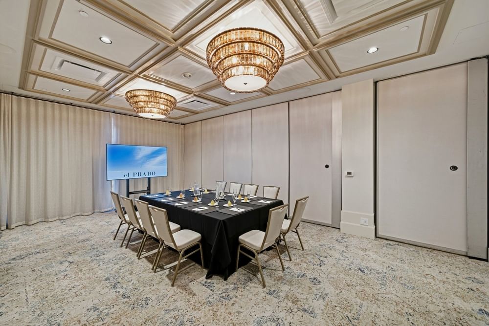 meeting room set up at el PRADO with a screen at the end of the table with white clouds against a blue sky