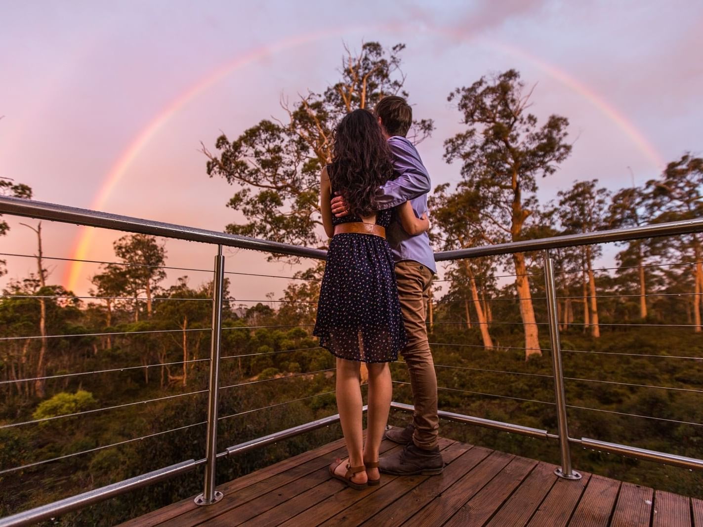 Couple looking at rainbow from Cradle Mountain Hotel