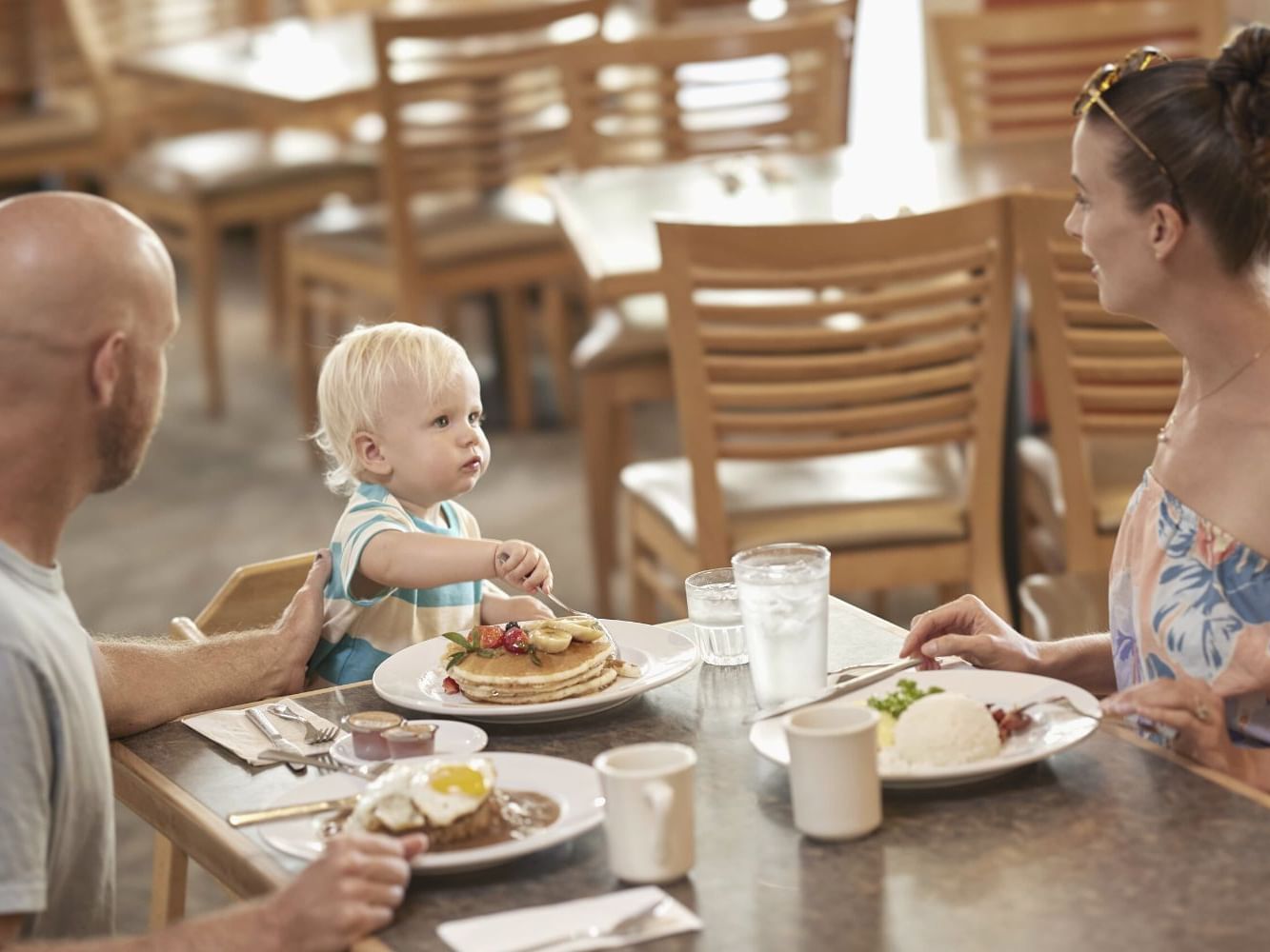 Family enjoying breakfast with pancakes in Ilima Cafe at Waikiki Resort Hotel by Sono