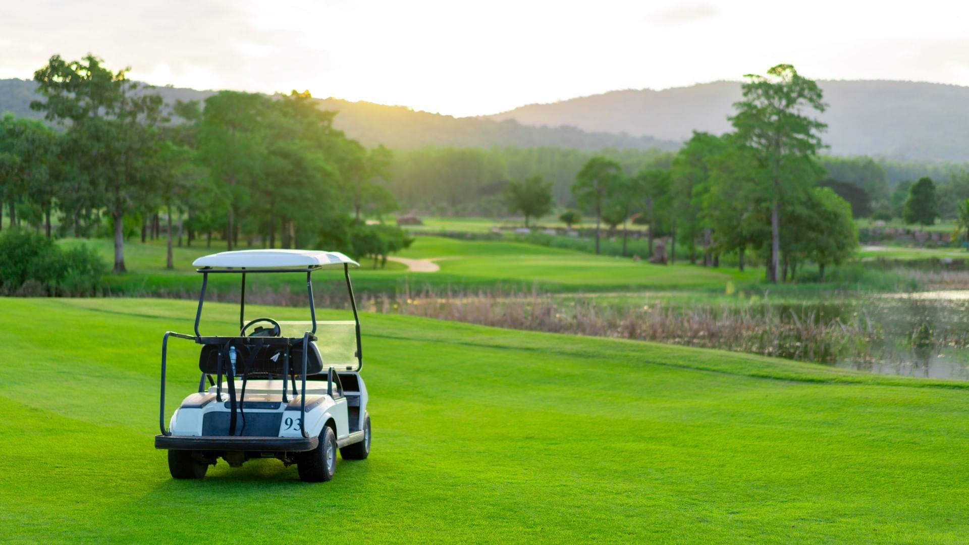Club Campestre Nuevo Laredo featuring a white golf cart parked on the grass at sunset near Real Inn Nuevo Laredo
