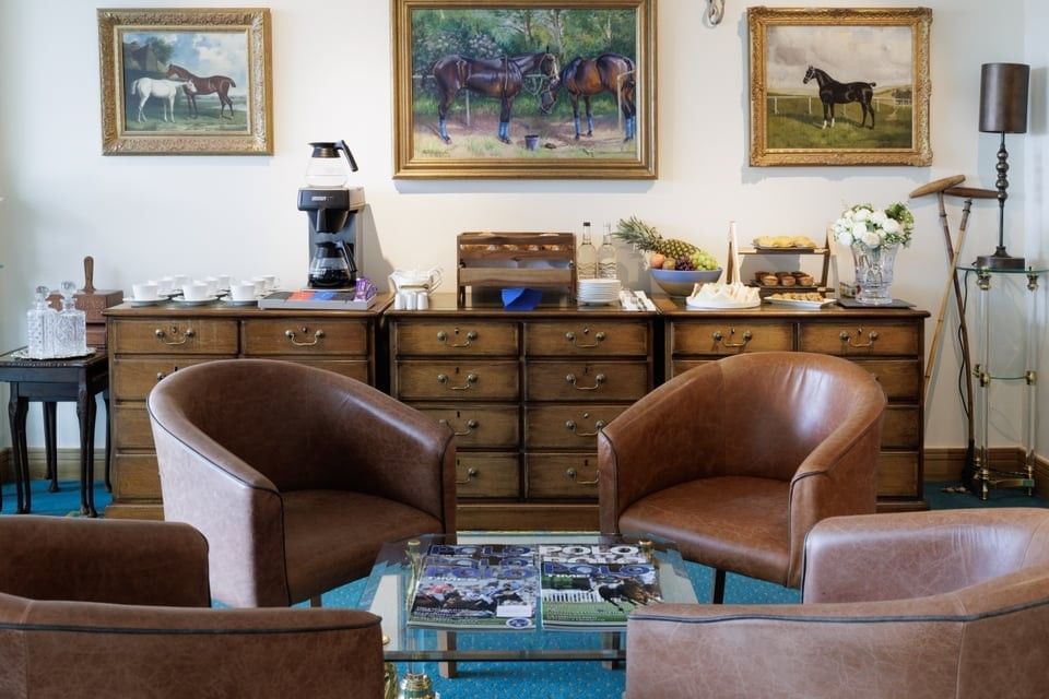 Leather armchairs around a glass table with a breakfast area at Polo Club Hotel, highlighting fine dining in Warwickshire